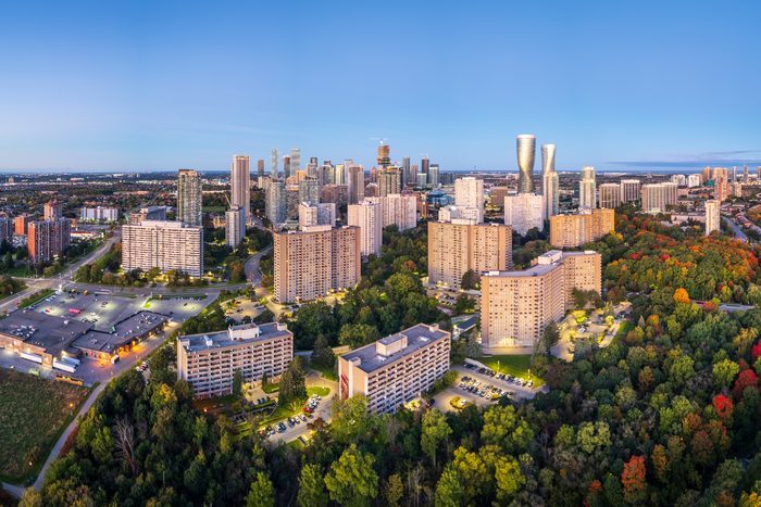 The Mississauga City Centre skyline at dusk with autumn trees in the foreground