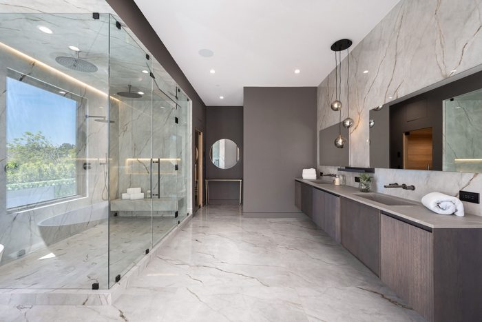 A marble bathroom with a glass shower enclosure after a deep clean
