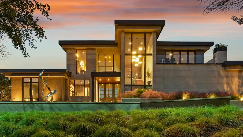 Contemporary home with tall windows and warm evening lighting