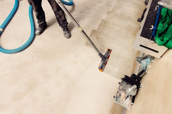 A floor machine cleaning a bare concrete subfloor after construction