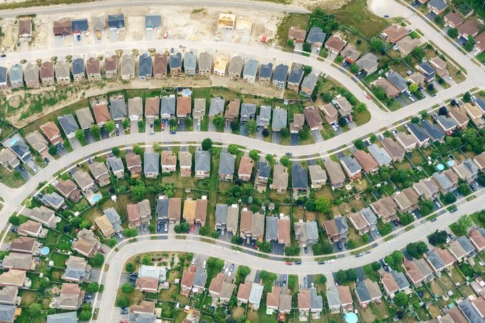 An aerial view of a suburban neighbourhood of detached homes and curving streets